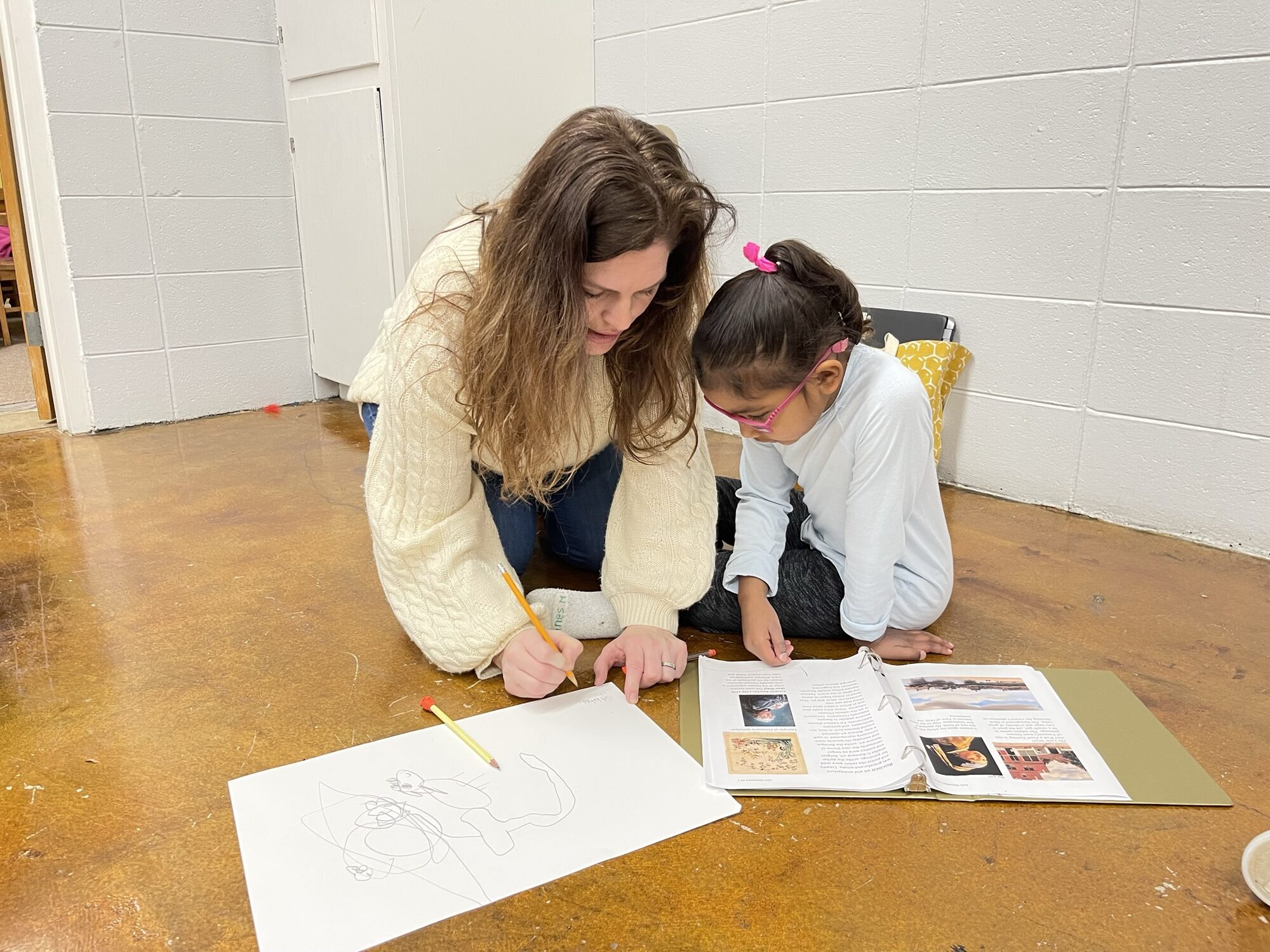 A tutor and a young student working on an art appreciation lesson