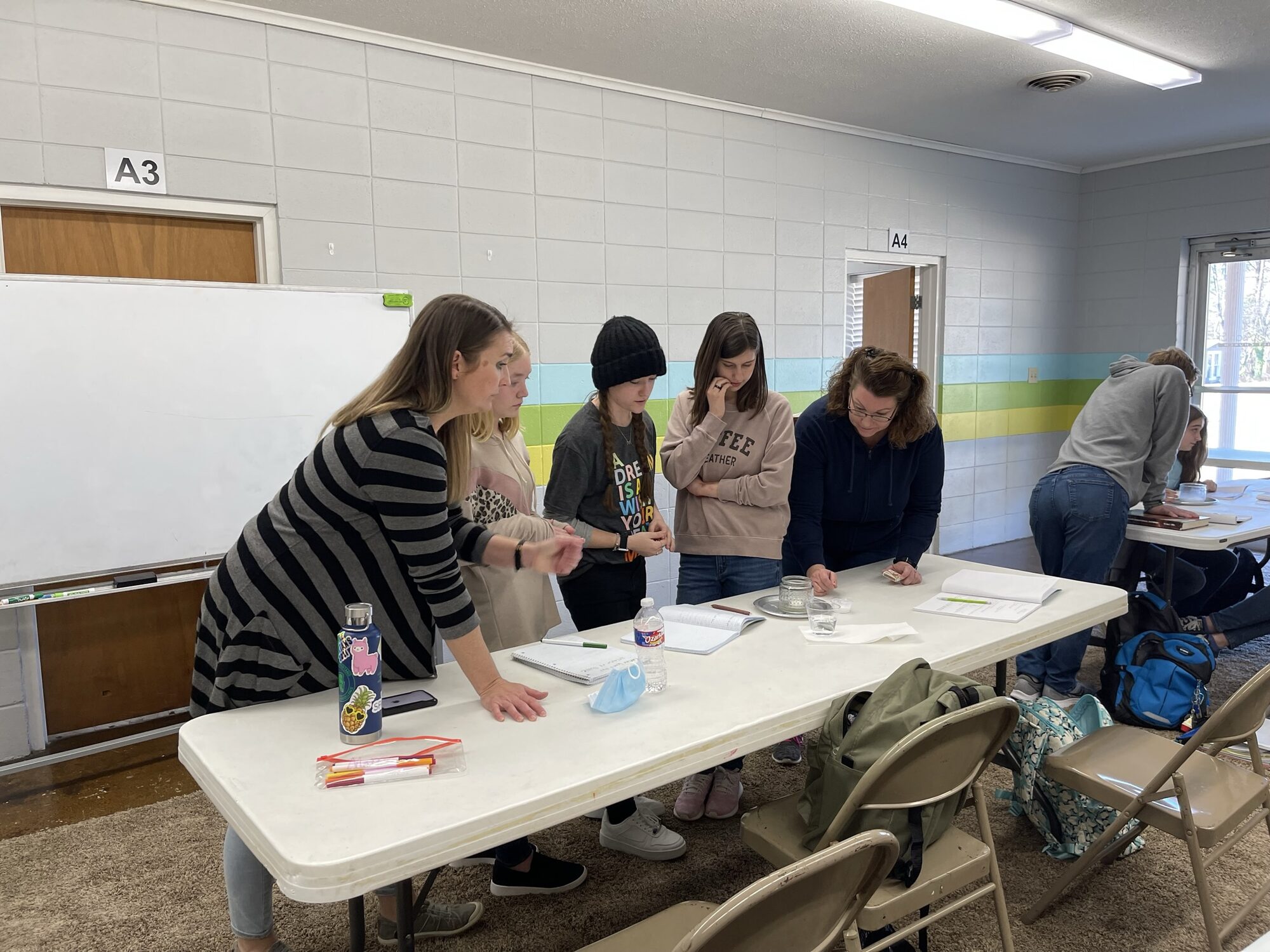 A tutor working with high school students around a table